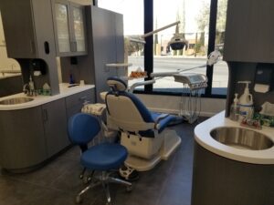 A close-up view of a dental work chair at Crystal Bright Smile Dental Office in Tujunga, CA. The space is clean and well-lit, with a modern blue and white color motif. The chair faces the window for a beautiful street view.