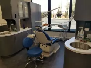 A close-up view of a dental work chair at Crystal Bright Smile Dental Office in Tujunga, CA. The space is clean and well-lit, with a modern blue and white color motif. The chair faces the window for a beautiful street view.