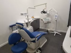 A close-up view of a dental work chair and equipment in an enclosed dental office at Crystal Bright Smile Dental Office in Tujunga, CA. The space is clean and well-lit, with a modern blue and white color motif.